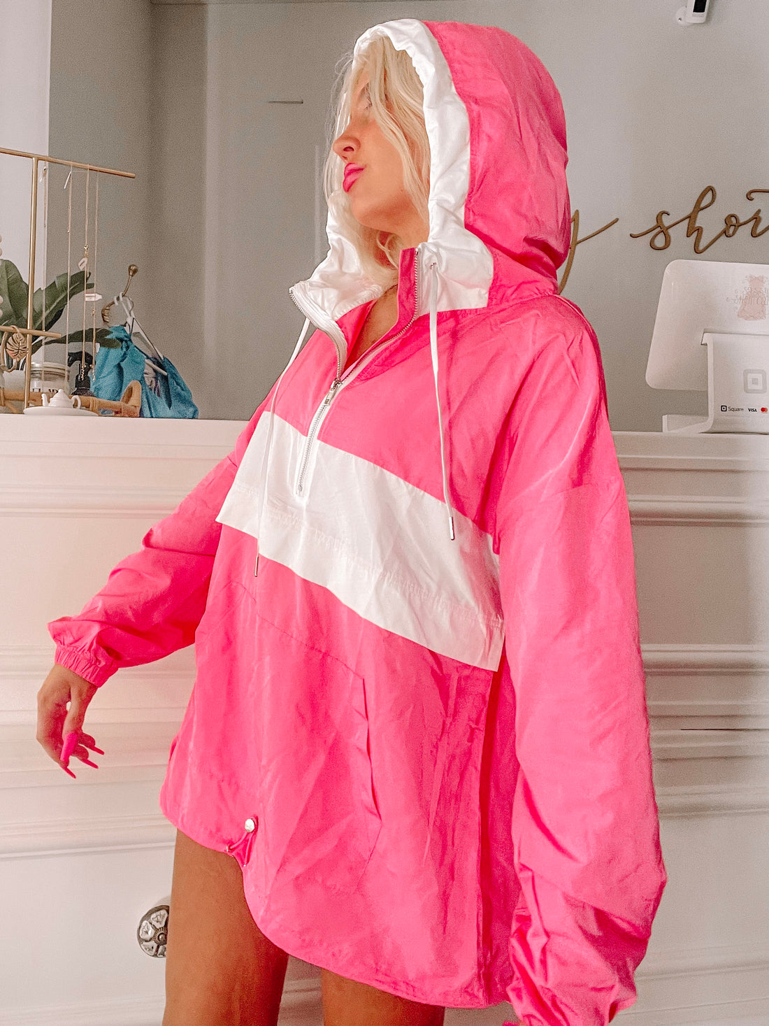 Hot pink windbreaker with white accents, modeled indoors.

