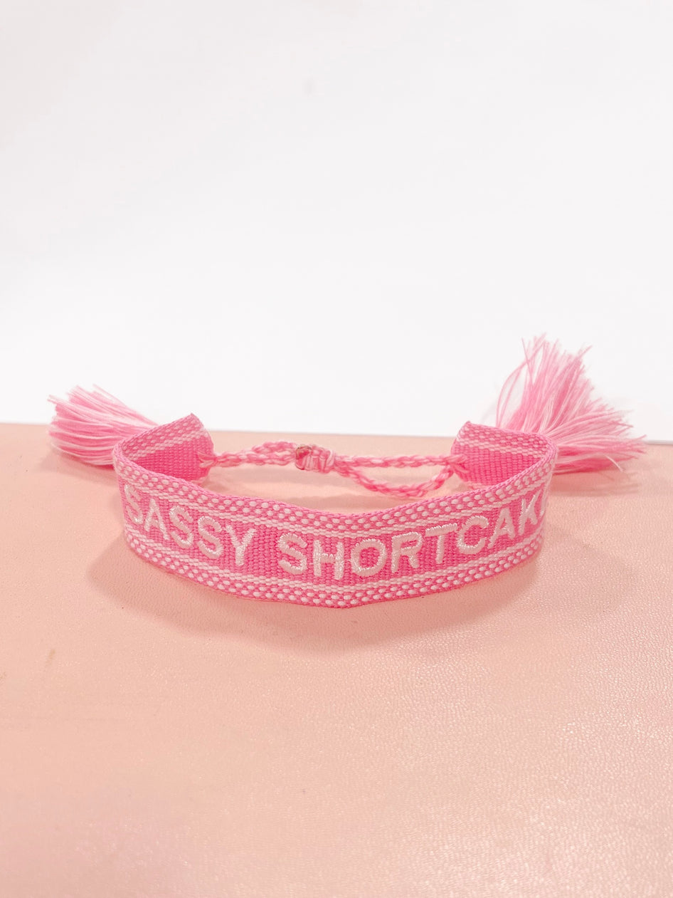 Pink "Sassy Shortcake" woven bracelet with tassels.
