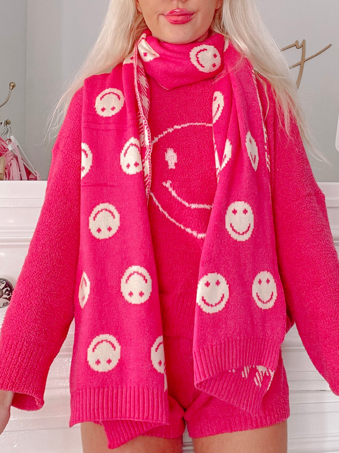 Pink smiley face scarf, soft knit, perfect for adding a cheerful touch to any outfit.
