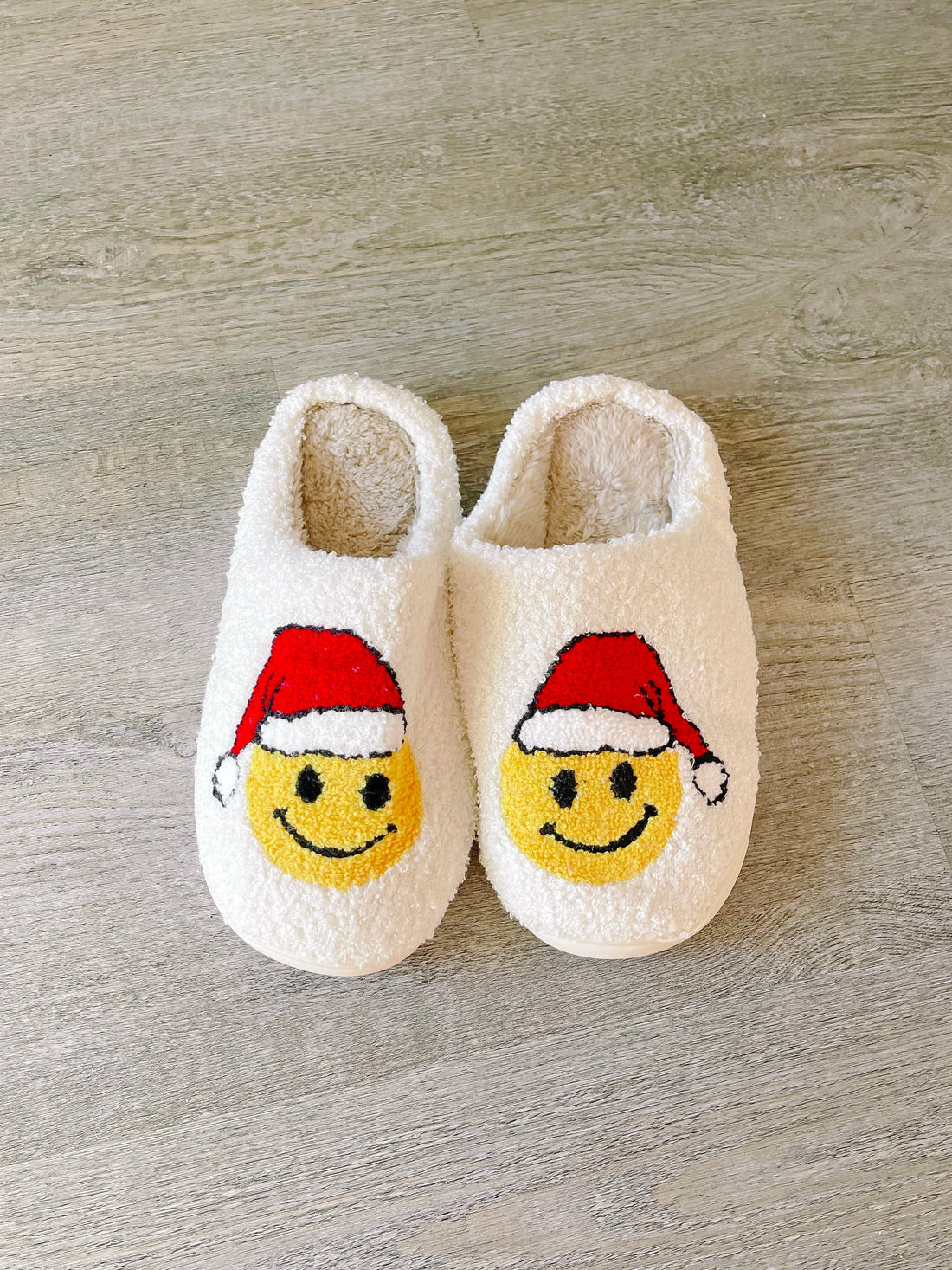 White Santa Smiley slippers with plush fleece lining for cozy comfort.
