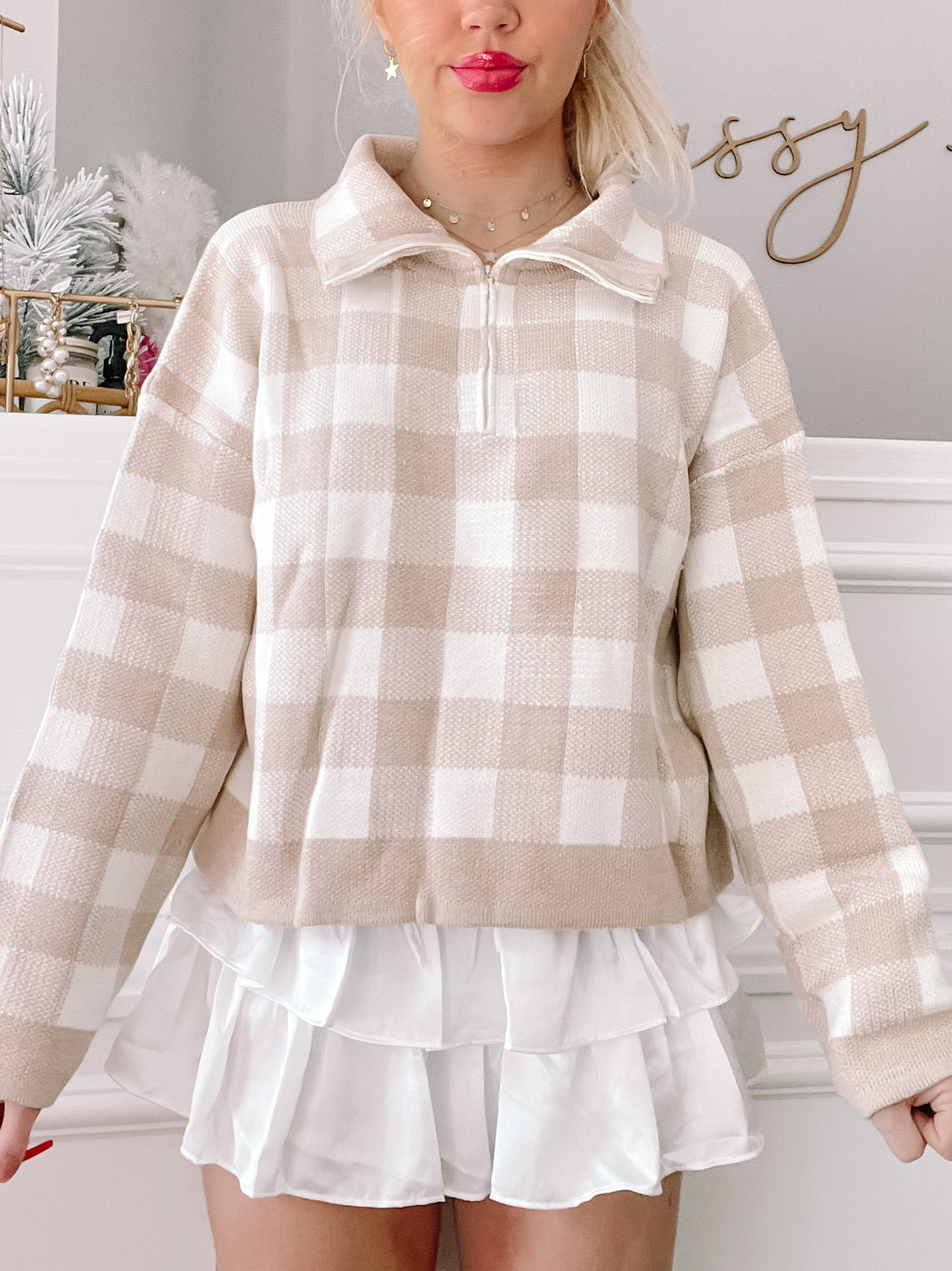 Cream and white gingham zip-up sweater styled with a white ruffled skirt.
