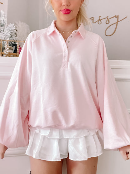 Pink Baby Brynn pullover top with balloon sleeves and button placket.
