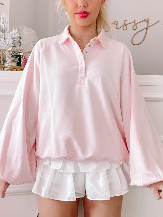 Pink Baby Brynn pullover top with balloon sleeves and button placket.
