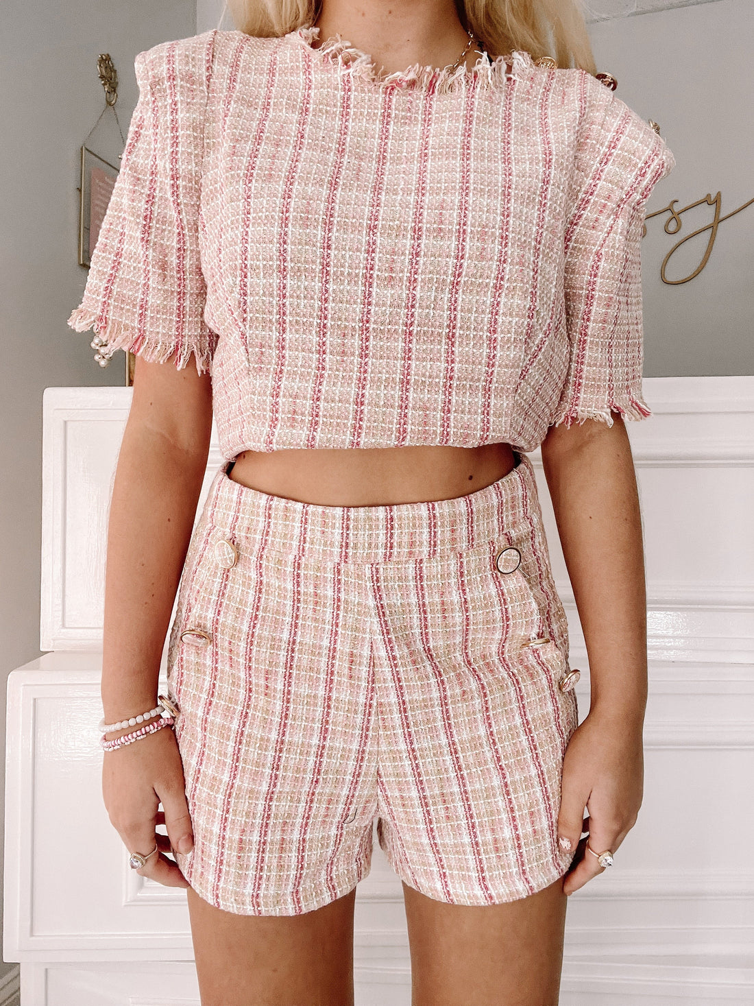 Pink and white tweed crop top and shorts set, textured fabric.

