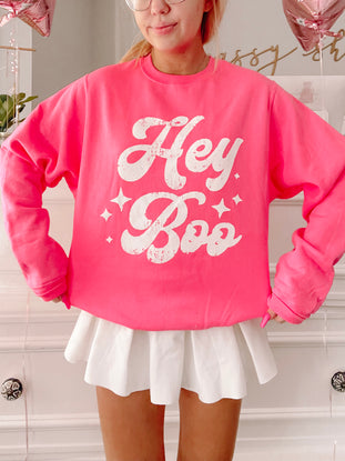 Hot pink Hey Boo crewneck sweatshirt with distressed white lettering and star details.
