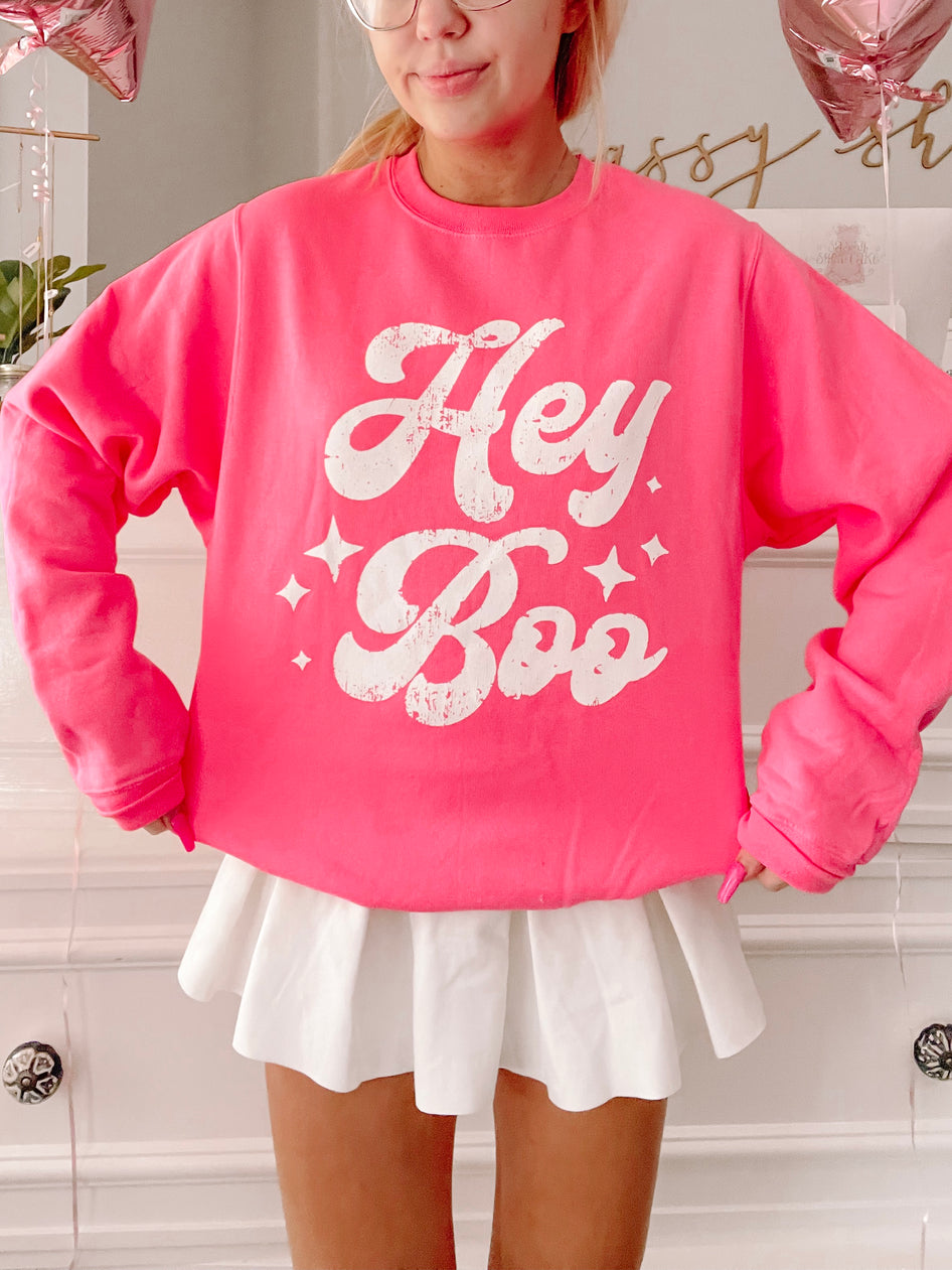 Hot pink Hey Boo crewneck sweatshirt with distressed white lettering and star details.
