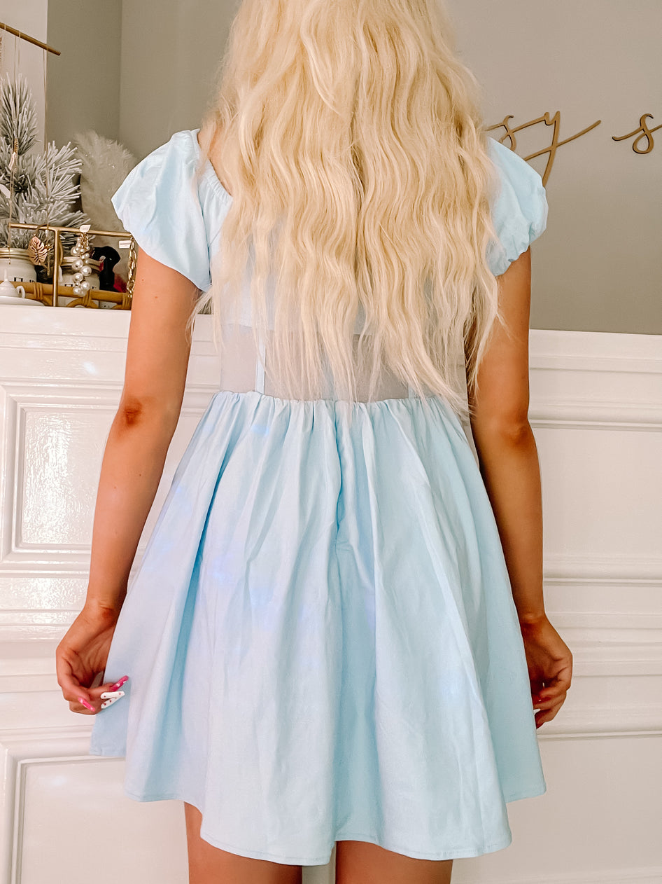 Light blue mini dress with puff sleeves, shown from the back against a white wall.
