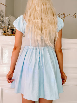 Light blue summer dress with puffed sleeves, shown from the back against a white background.

