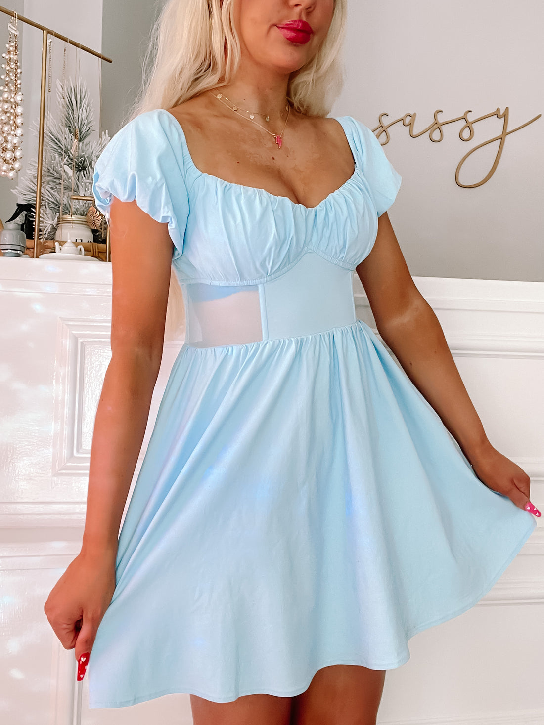 Light blue summer dress with puff sleeves and a fitted bodice;  model showcases the fit against a white background.
