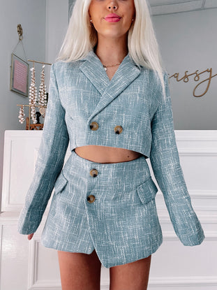 Light blue cropped blazer and mini skirt set, tweed-like texture.
