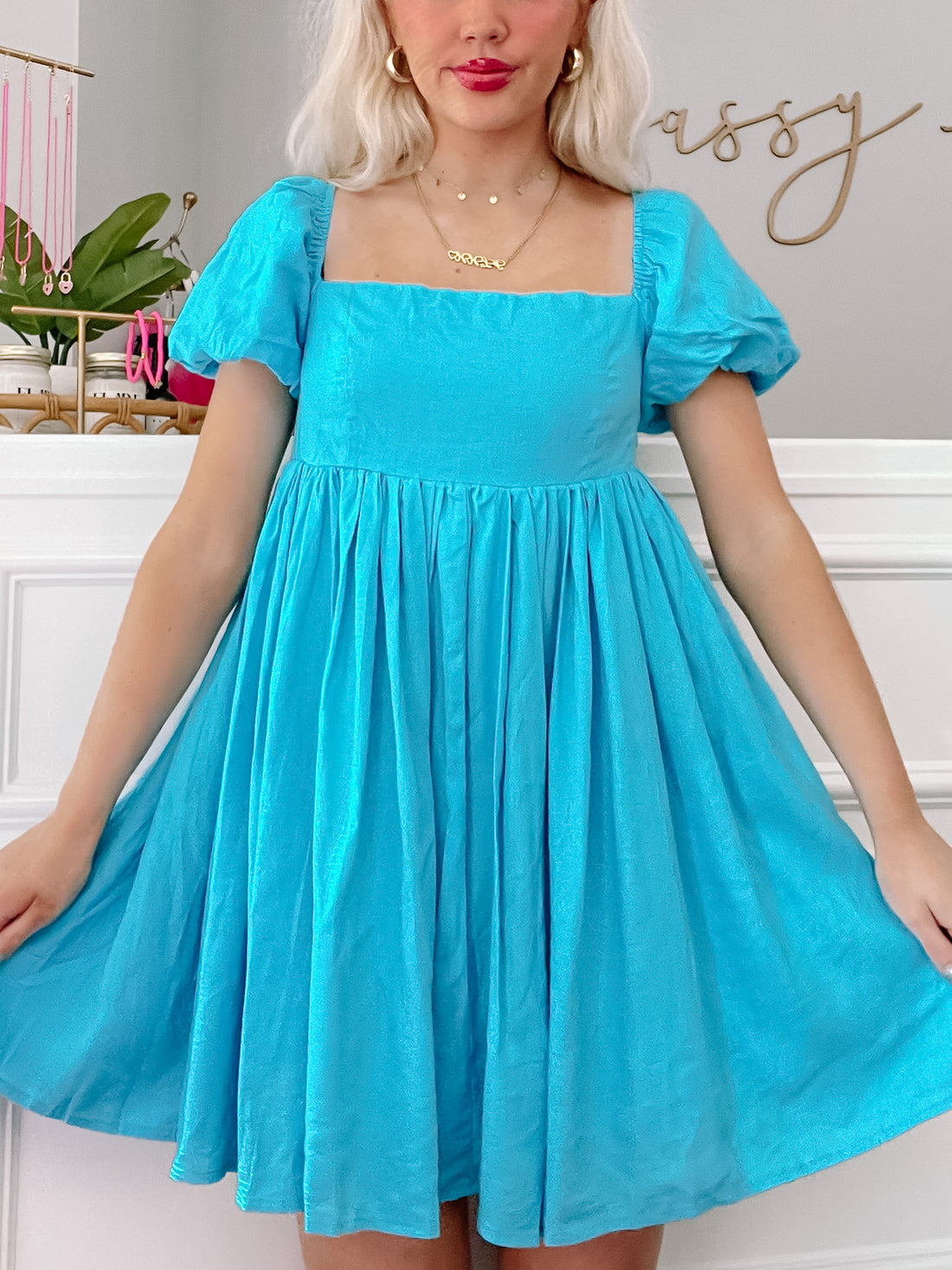 Electric blue mini dress with puff sleeves and square neckline, shown on a model.
