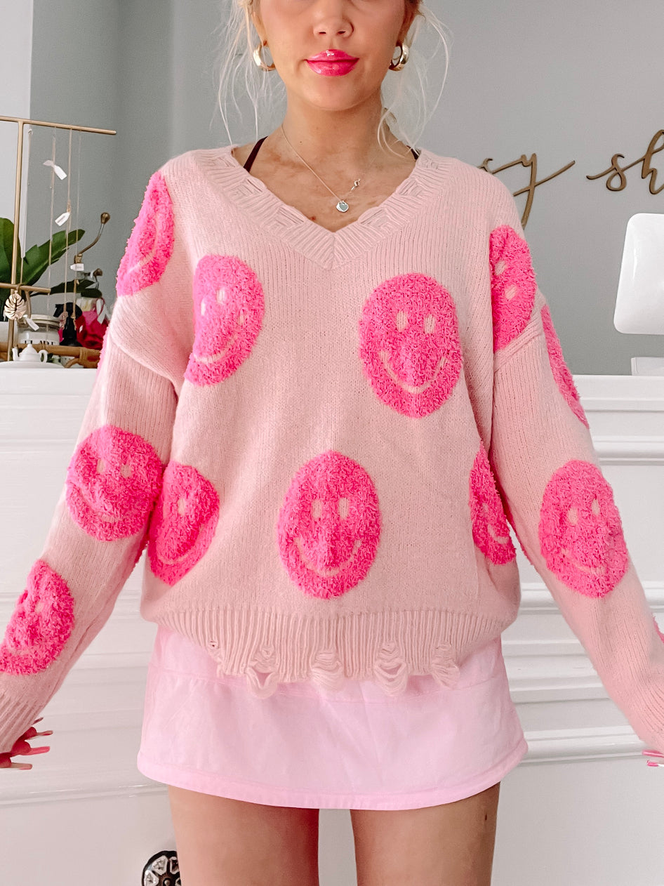 Pink Smile Struck fuzzy sweater with pink smiley faces.
