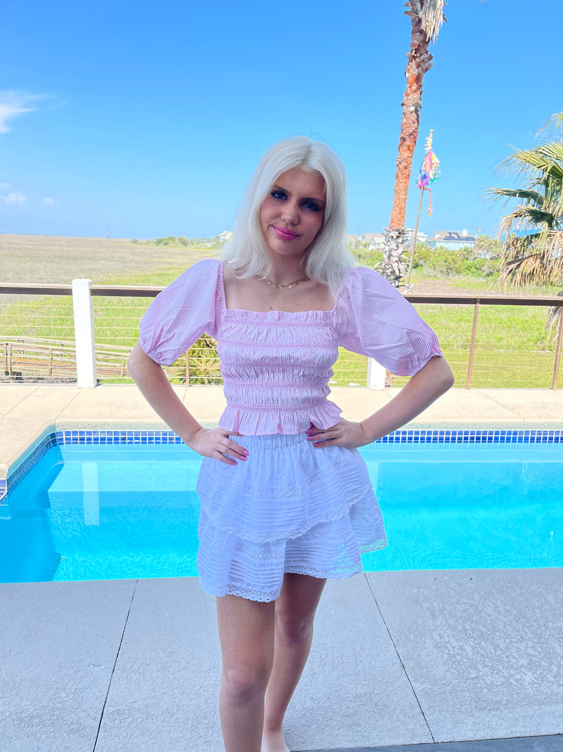 Pink striped crop top and white tiered mini skirt, poolside summer fashion
