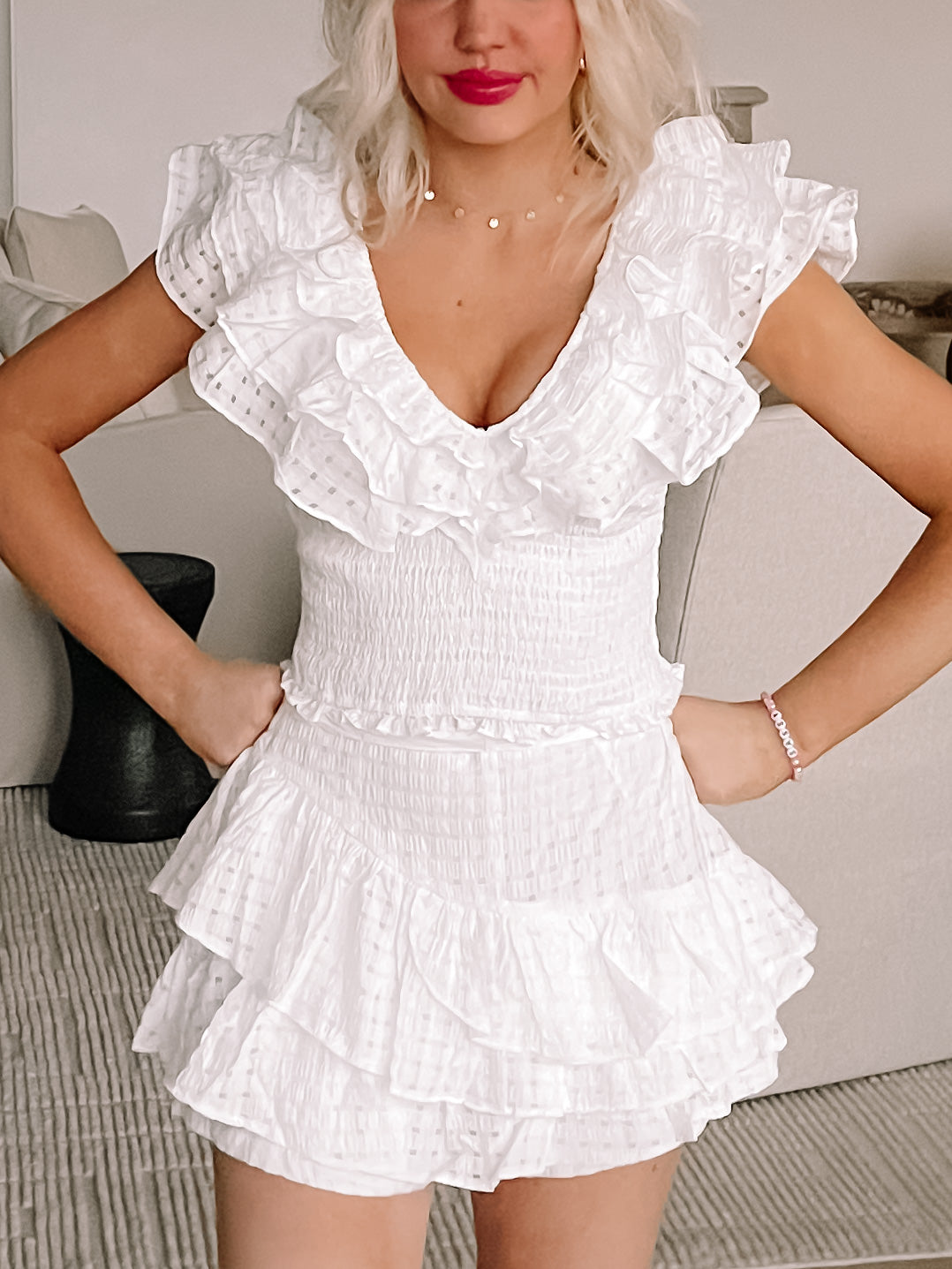 White eyelet ruffle two-piece set; layered ruffles, smocked bodice, and skirt.
