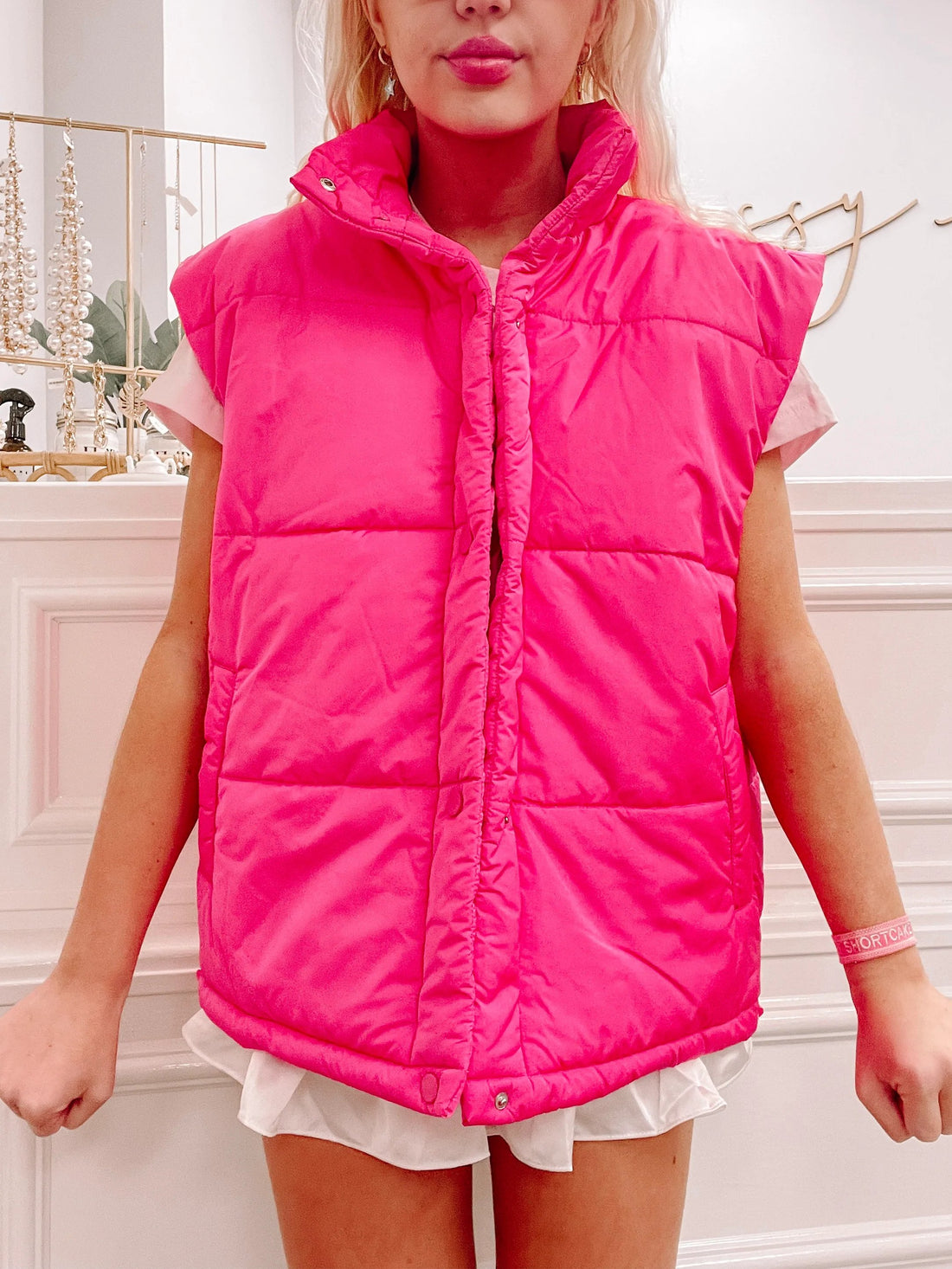Hot pink puffer vest, sleeveless, zipper closure.
