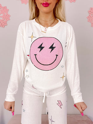 White Electric Dreams PJ set featuring a pink smiley face graphic with lightning bolts and stars.
