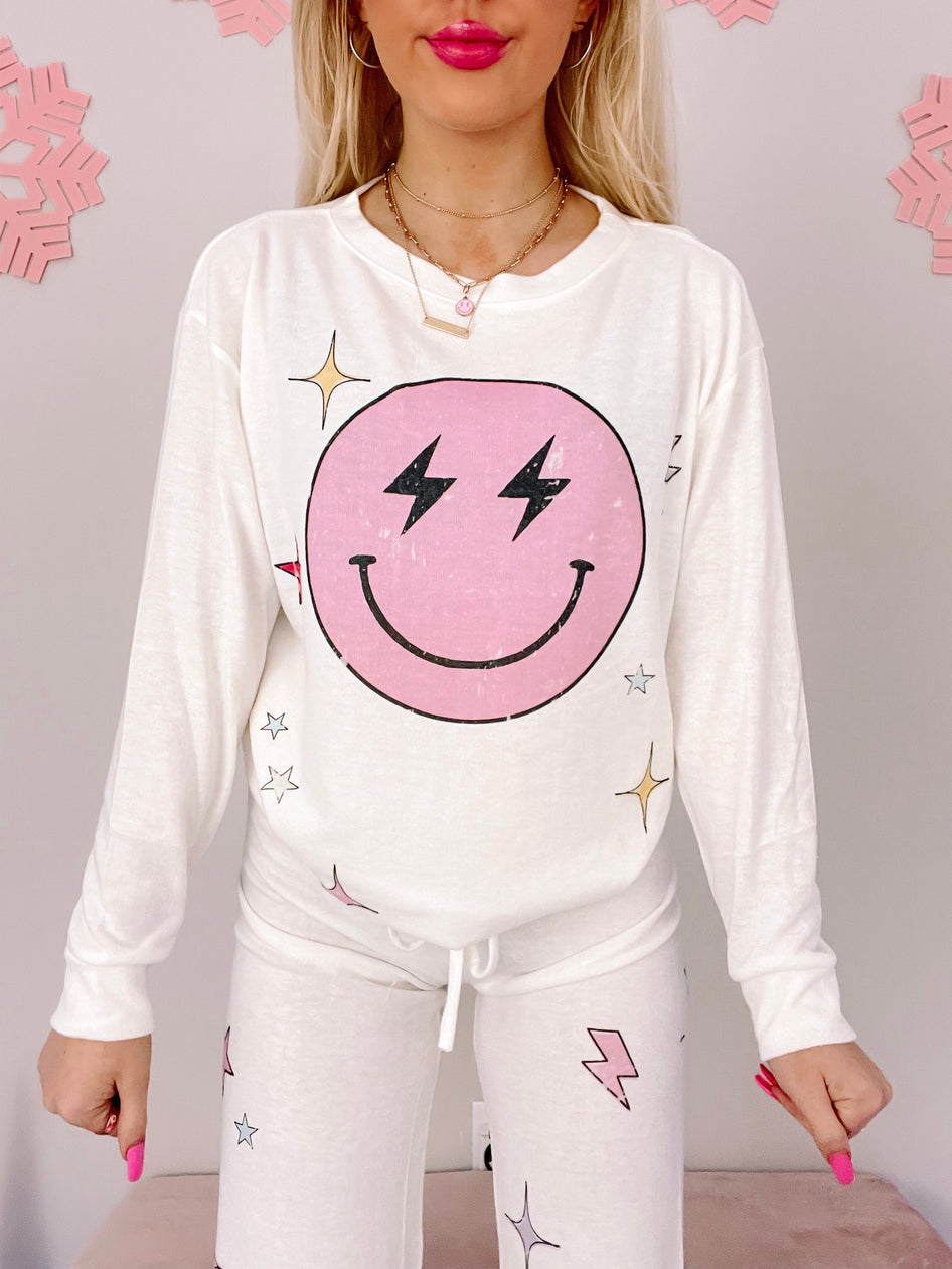White Electric Dreams PJ set featuring a pink smiley face graphic with lightning bolts and stars.

