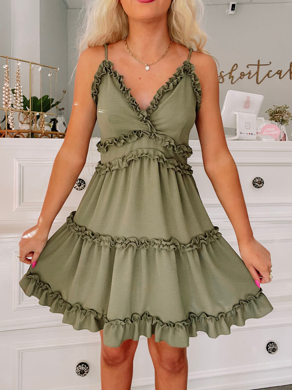 Olive green ruffle mini dress with tiered ruffles and adjustable straps.
