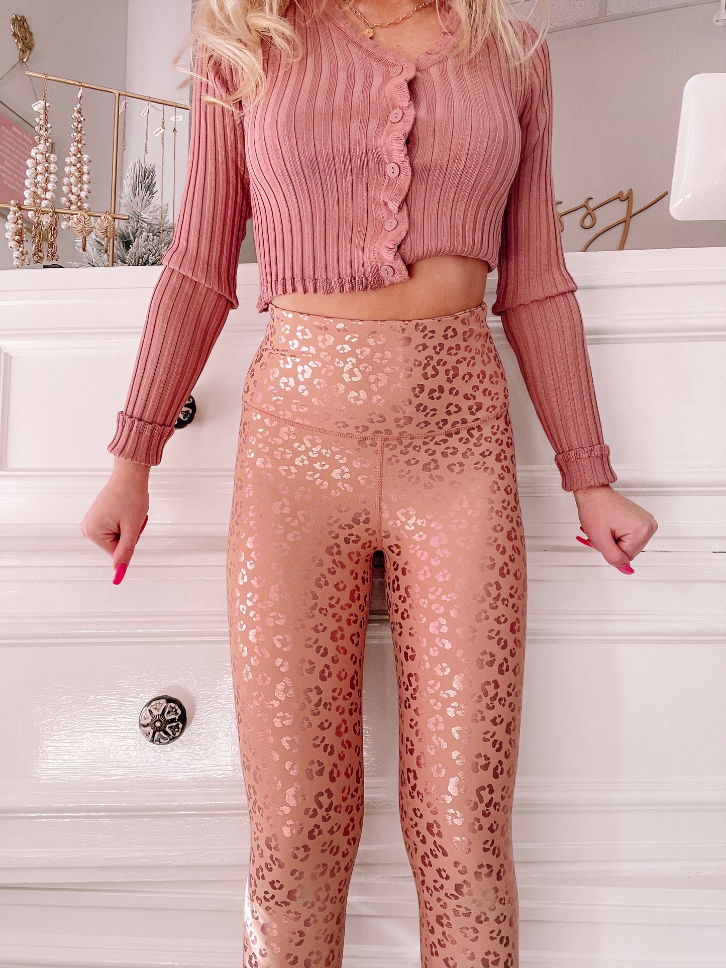 Rose gold leopard-print leggings against a white background.
