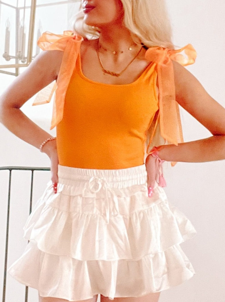 Orange Brynn bodysuit with sheer orange ribbon shoulder ties.
