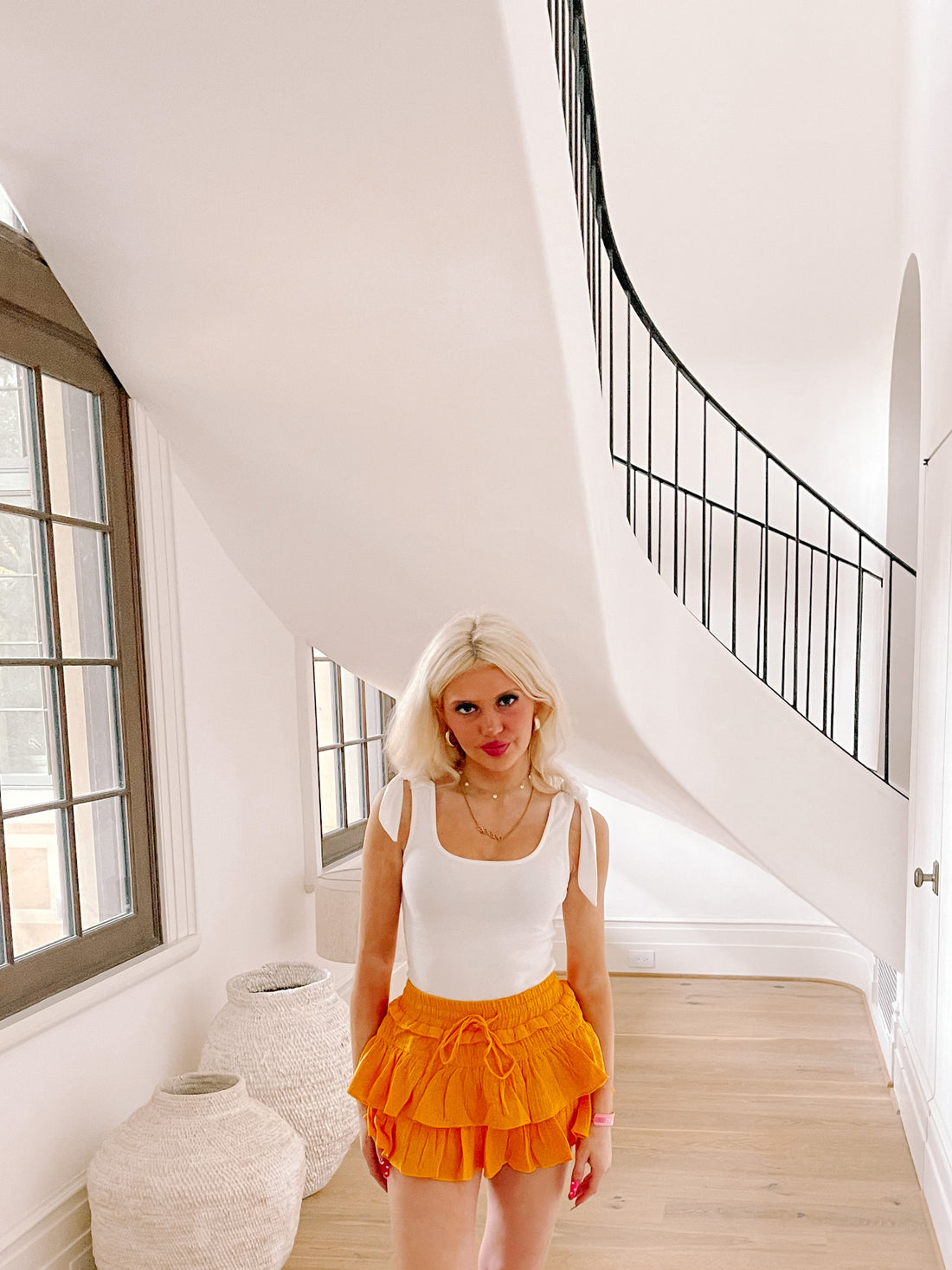 Marigold orange ruffle mini skirt styled in a bright, modern home.
