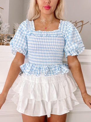 Blue Bonnet Top: Baby blue gingham smocked crop top with puff sleeves and ruffled trim.
