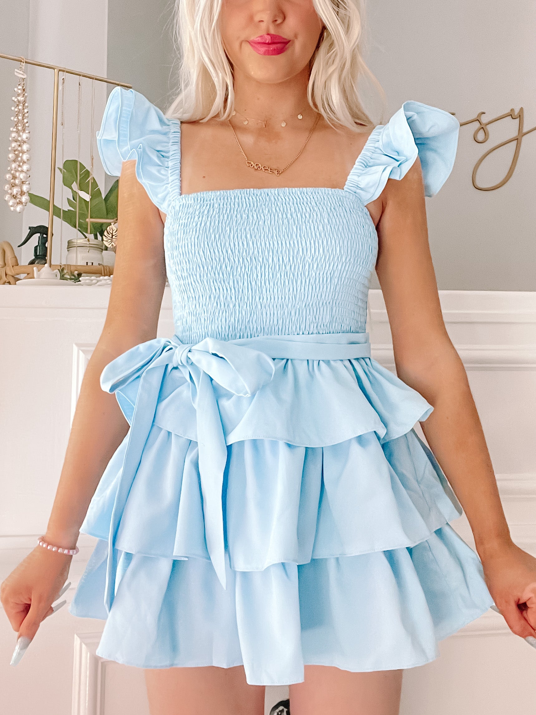 Sweet Sorbet Dress in light blue featuring a smocked bodice, ruffle sleeves, and tiered skirt.
