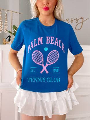 Palm Beach Tennis Club Preppy Tee in blue, featuring pink tennis rackets and "Est. 1909" graphic.
