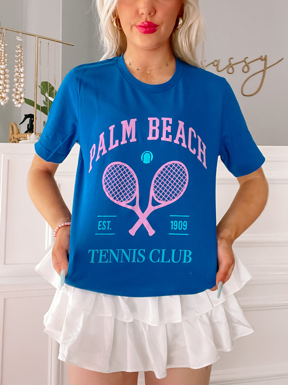 Palm Beach Tennis Club Preppy Tee in blue, featuring pink tennis rackets and "Est. 1909" graphic.
