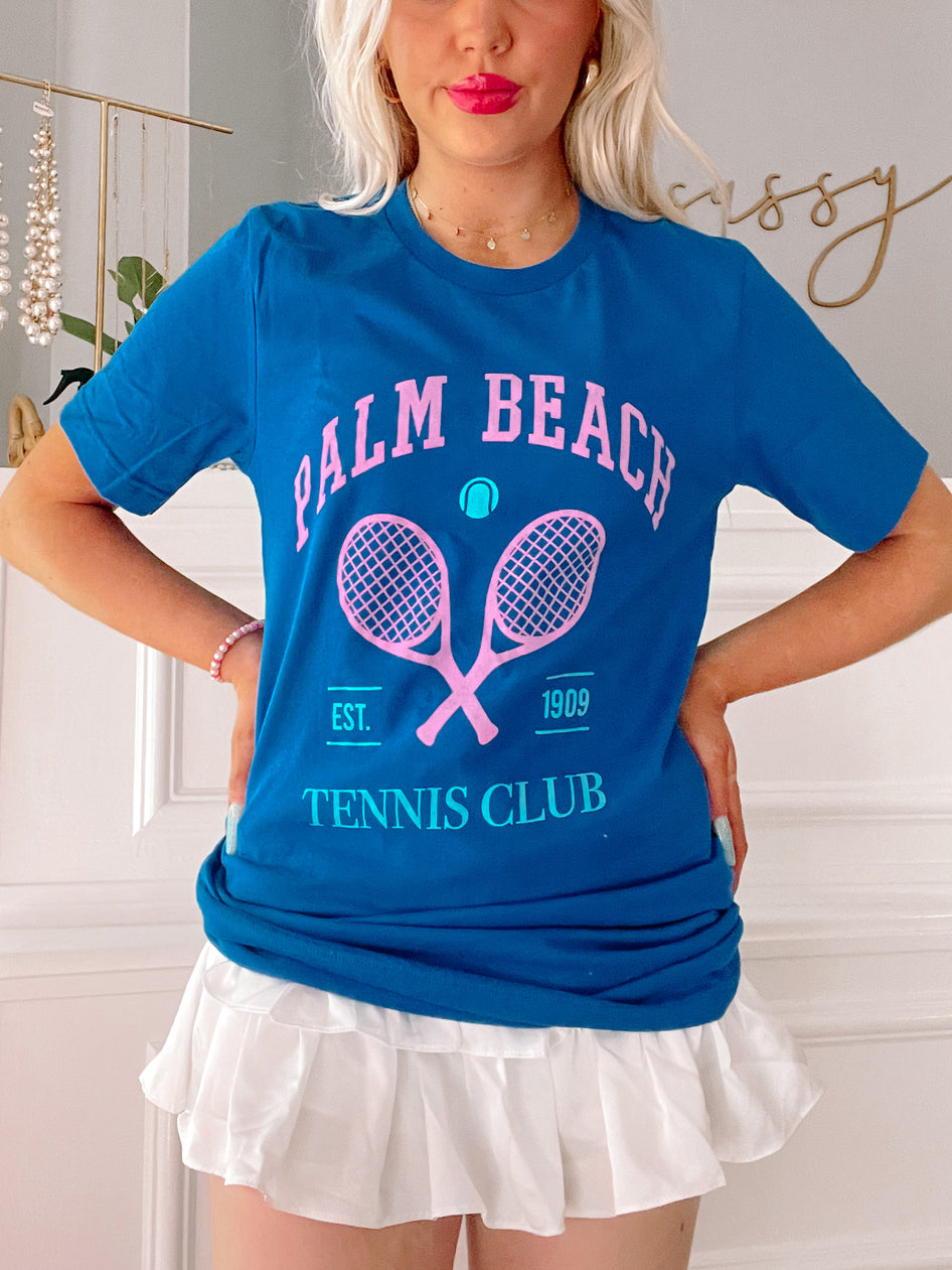 Blue tennis-themed tee shirt featuring crossed tennis rackets and Palm Beach Tennis Club logo.
