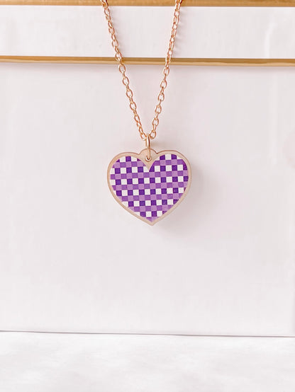 Rose gold chain necklace with a purple gingham heart pendant.
