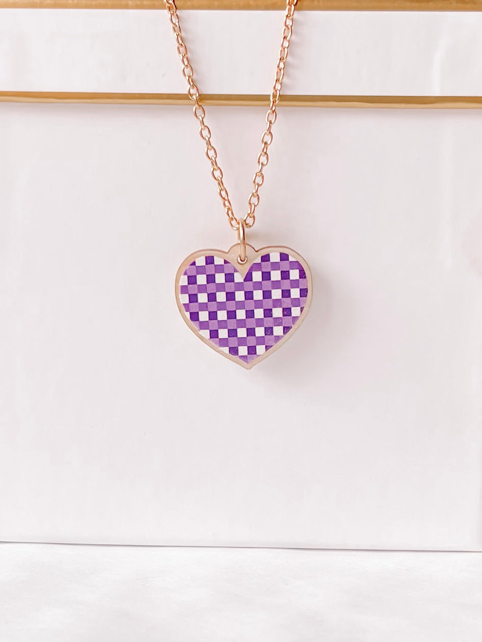 Rose gold chain necklace with a purple gingham heart pendant.

