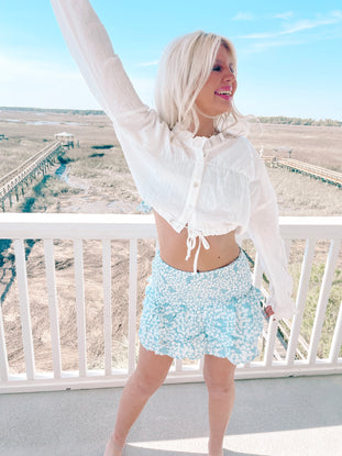 White crop top and light blue floral print mini skirt outfit.
