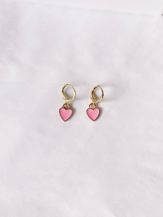 Pink heart dangle earrings with gold hoops, displayed on white background.