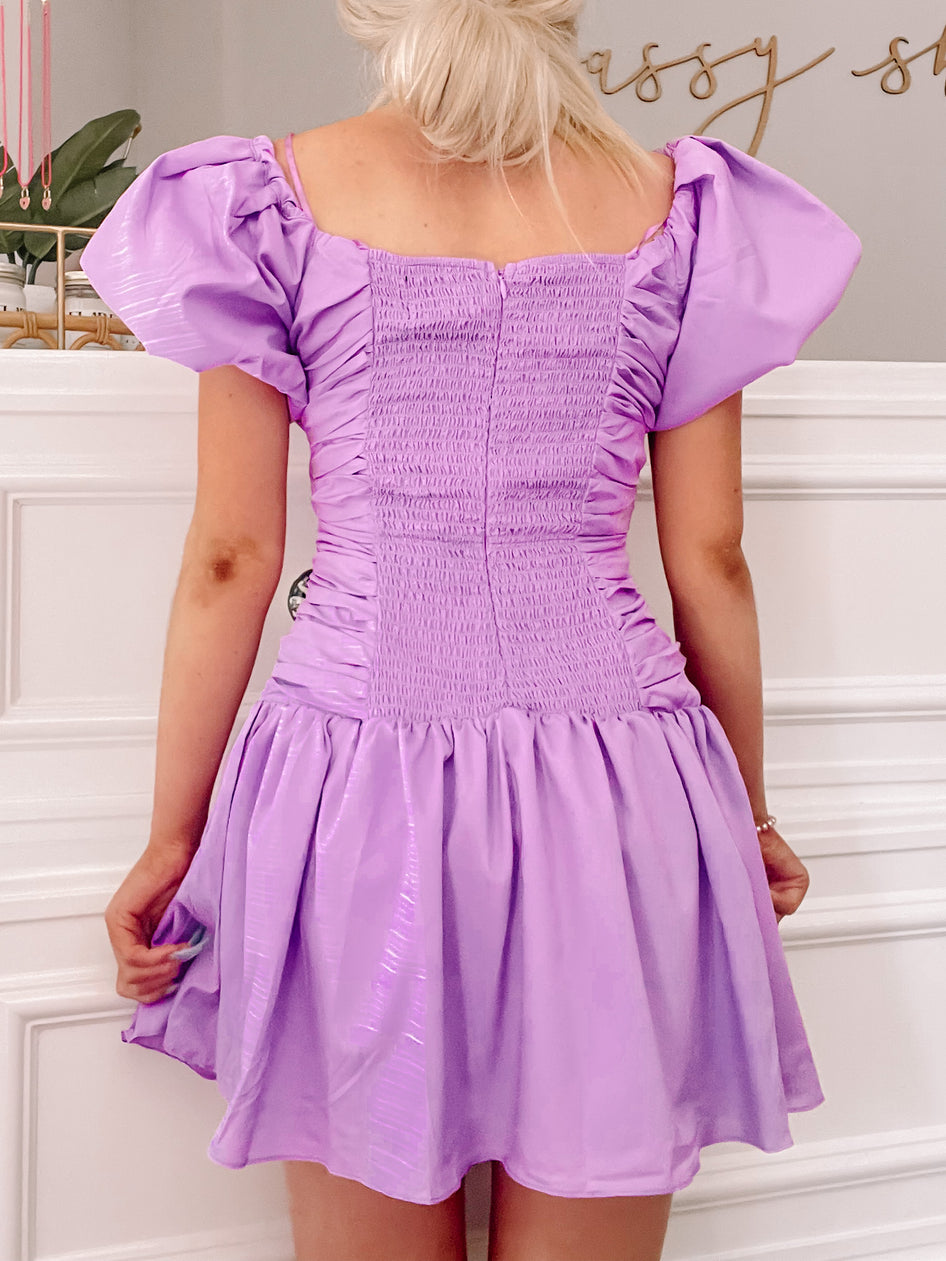 Lilac mini dress with puff sleeves and smocked bodice, shown from the back.
