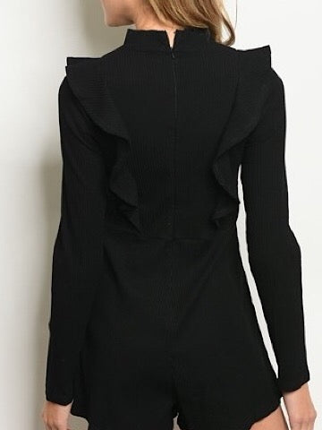 Black ribbed romper with ruffle detailing, long sleeves, and a mock neck.

