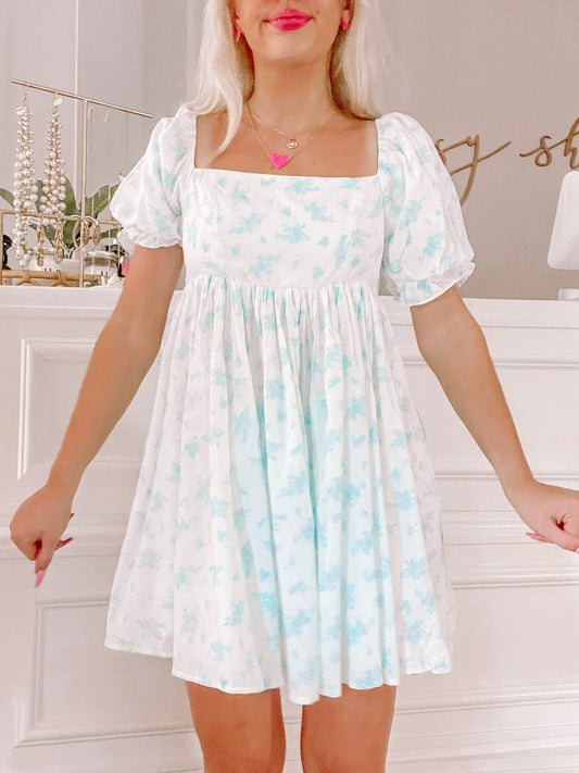 Blue floral mini dress with puff sleeves, shown on a model.