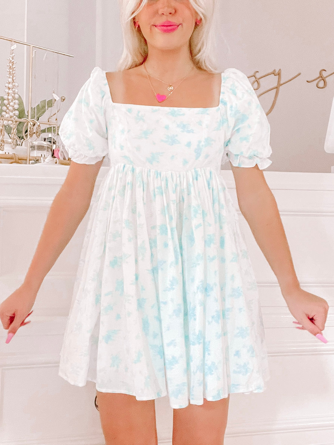 All Dolled Up Dress in blue:  A cute, light blue floral mini dress with puff sleeves and square neckline.

