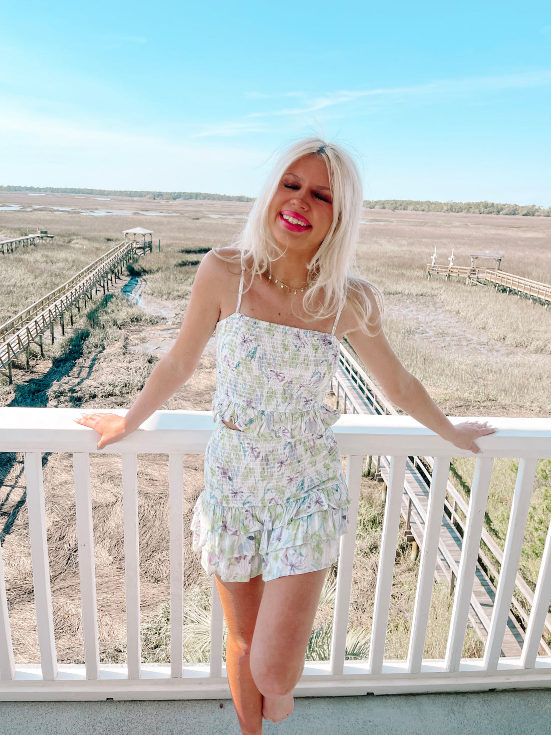 Floral print two-piece summer outfit: white crop top and ruffled shorts.
