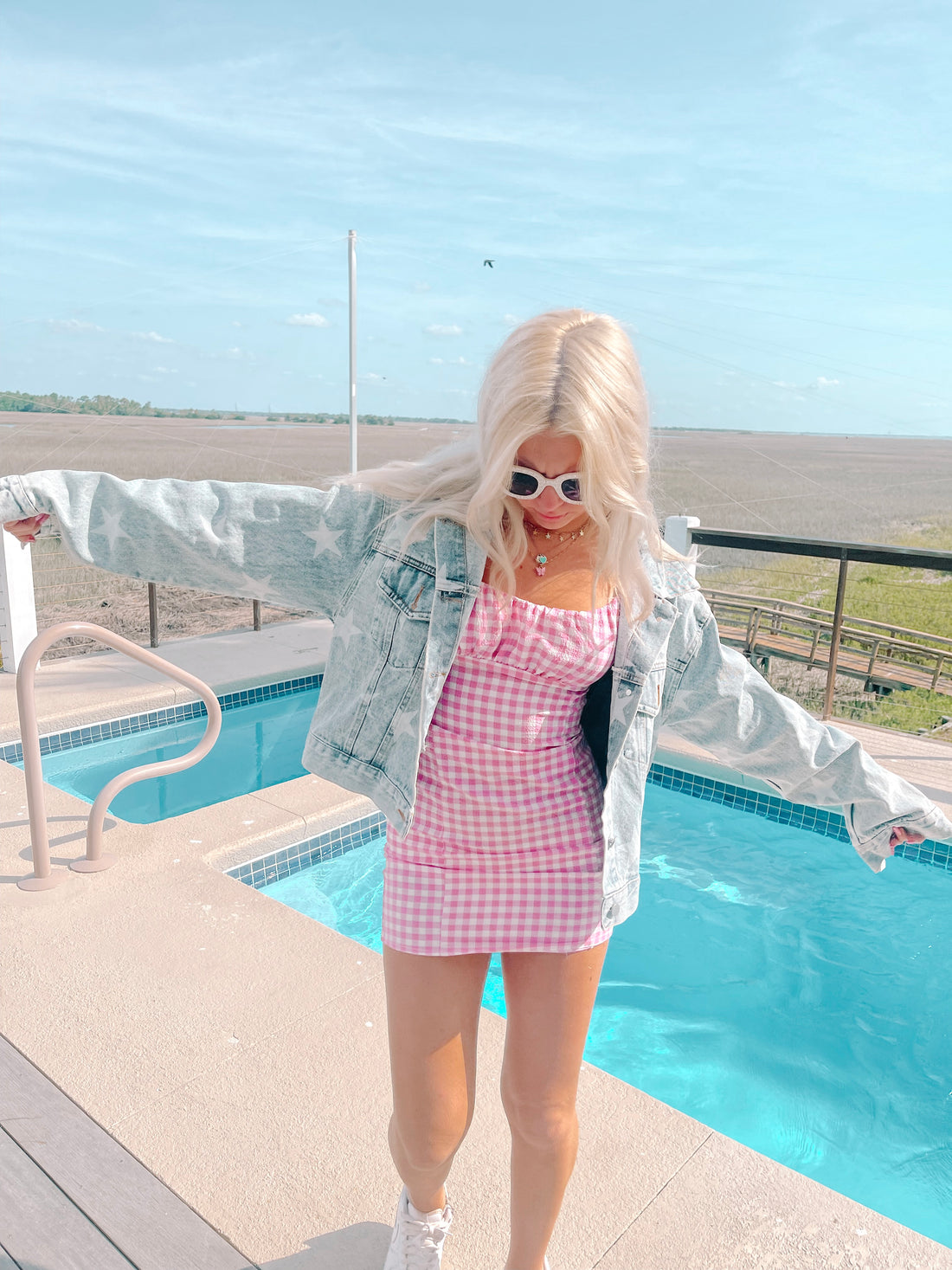 Light wash denim jacket with star accents, worn poolside.
