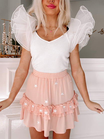 Peach mini skirt with white star embroidery & ruffle trim.

