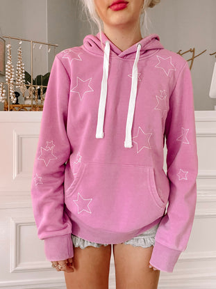 Lavender purple hoodie with white star accents, casual lifestyle shot.
