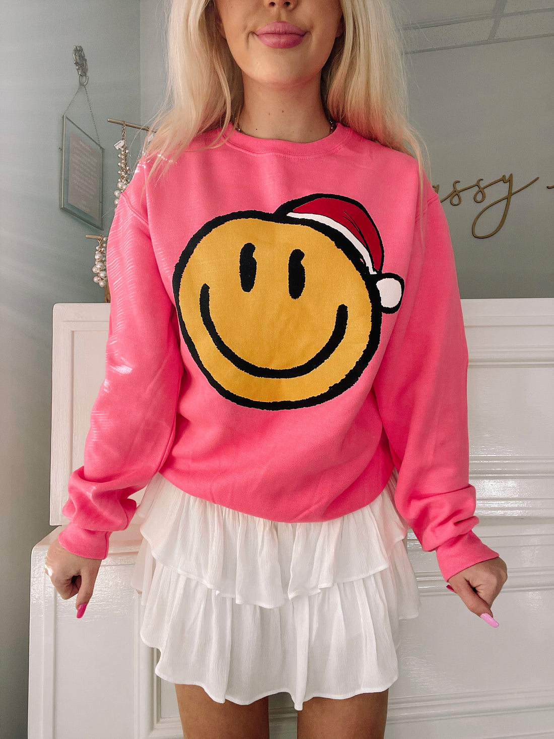 Pink Santa Smiley sweatshirt featuring a festive yellow smiley face design.
