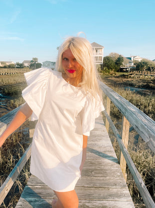 White cotton puff-sleeve mini dress, perfect for summer.
