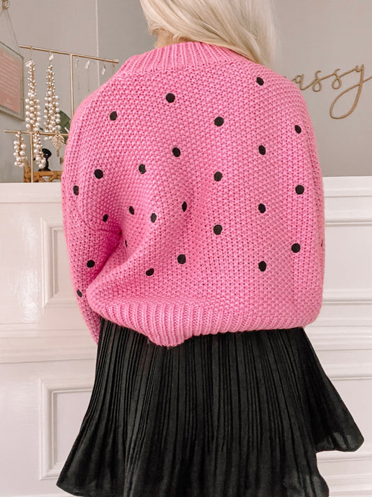 Pink knit sweater with black polka dots, shown from the back.