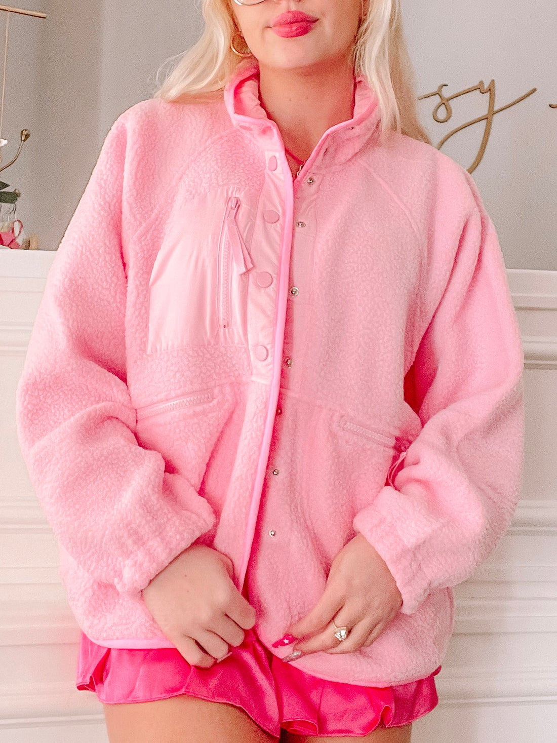 Bubblegum pink fleece jacket with snap button closure, shown on model.
