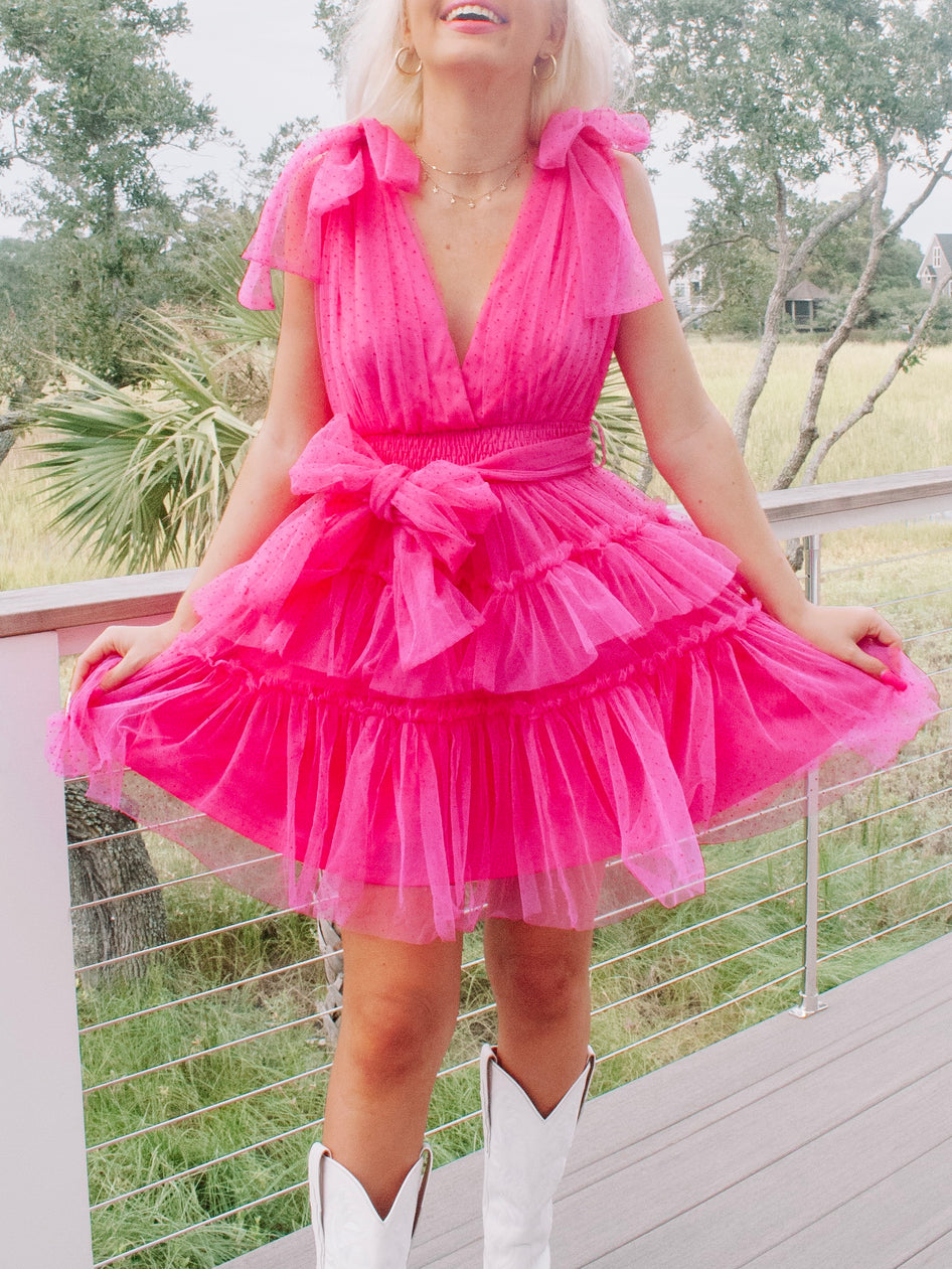 Hot pink tulle mini dress with bow details; perfect for parties.
