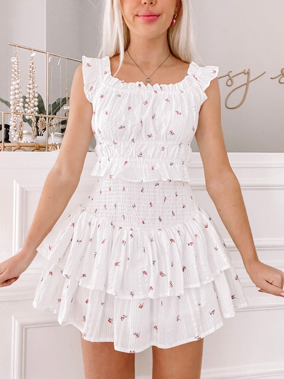 White floral two-piece outfit; tiered ruffle skirt and smocked crop top.
