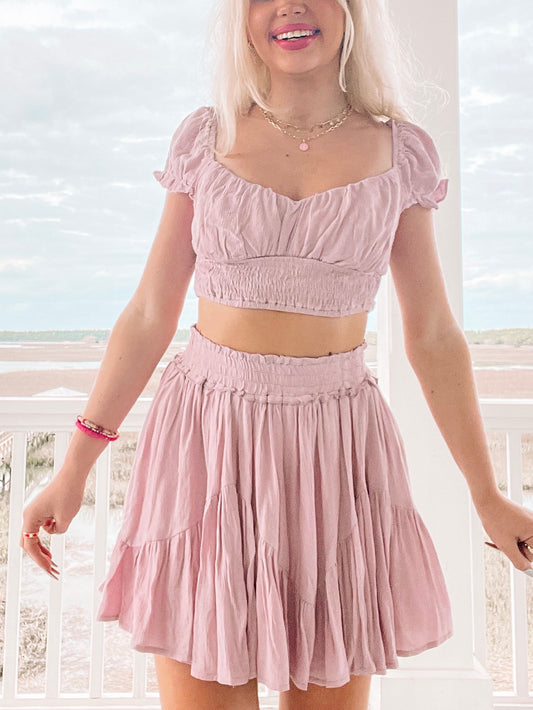 Lilac two-piece outfit; crop top and flowy mini skirt, worn outdoors on a porch.