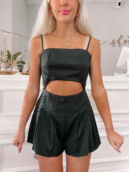 Black cut-out romper with pleated shorts.
